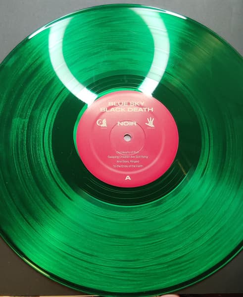 Close up of green vinyl (side A and B) of 10-year anniversary pressing of Blue Sky Black Death's Noir.