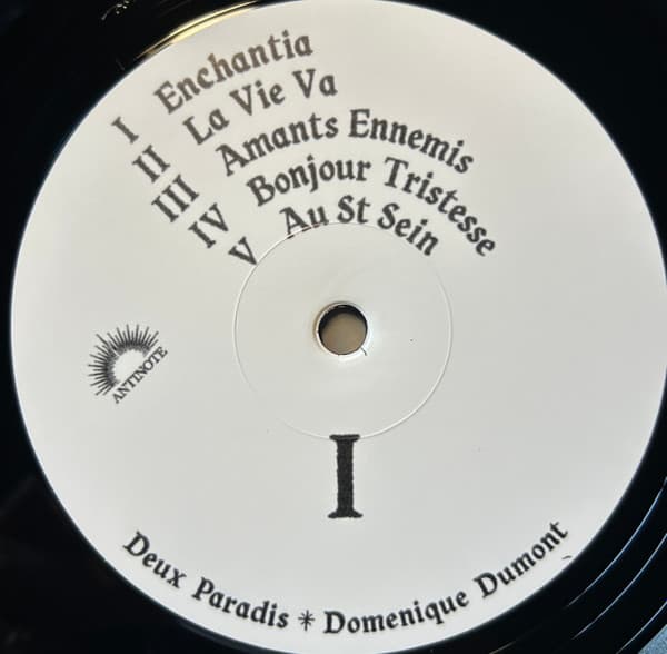 Vinyl record label with text and a logo on a black background