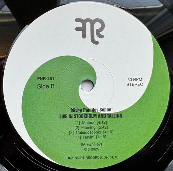 Vinyl record label with green and white design, featuring text and a logo.