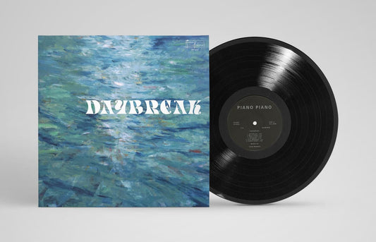 Vinyl record with a blue abstract cover and 'Daybreak' text on a gray background