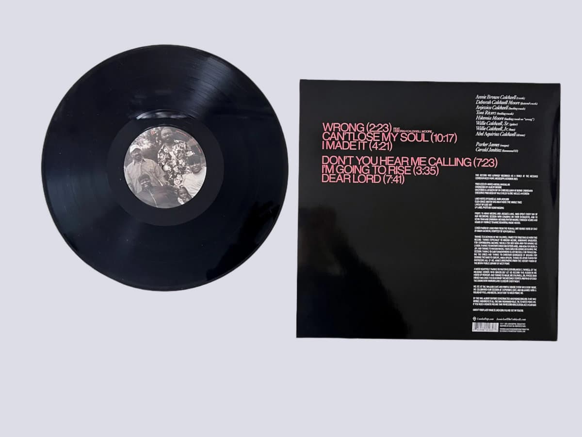 Vinyl record with cover displaying tracklist on a light gray background