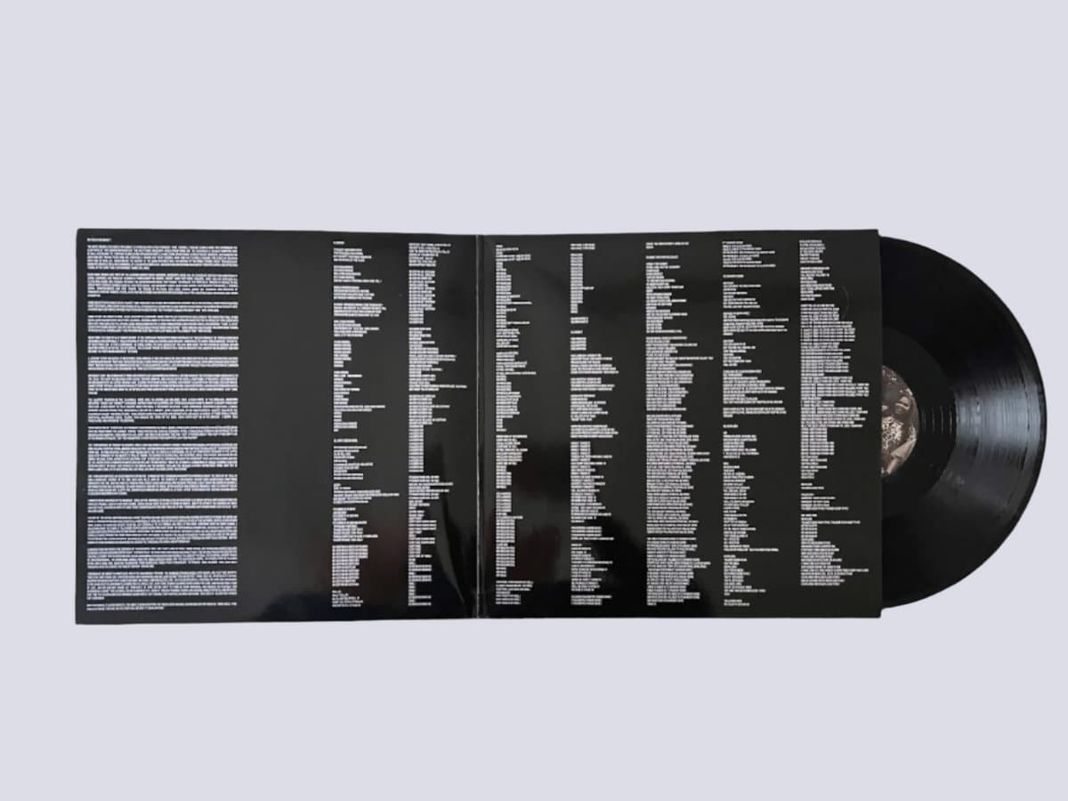 Vinyl record with a black cover featuring white text on a light gray background