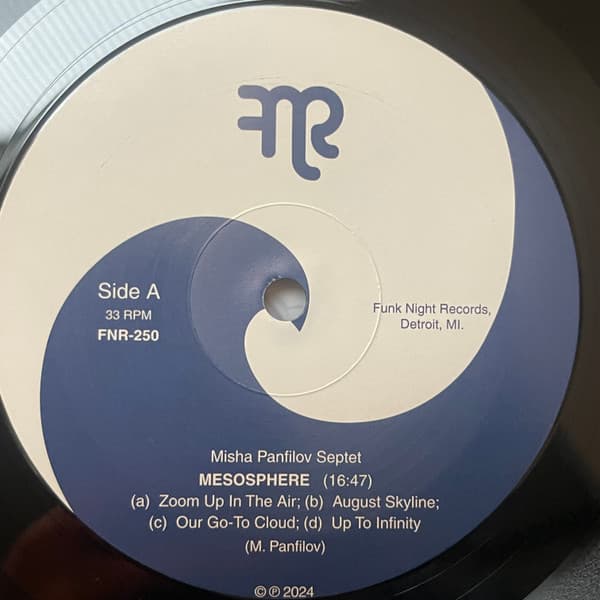 Vinyl record label with text and a logo on a blue and beige background