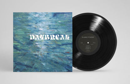 Vinyl record with a blue abstract cover and 'Daybreak' text on a gray background