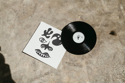 Vinyl record and cover for Tasmin - Tezeta with abstract designs on a concrete surface
