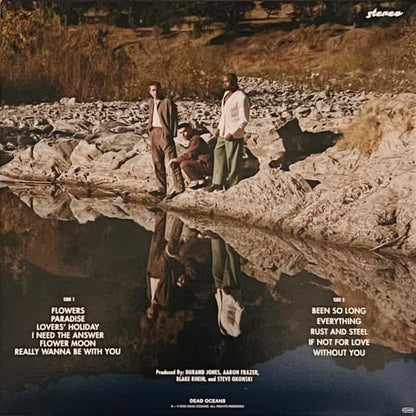 Album cover with three people by a river, featuring text and production credits.